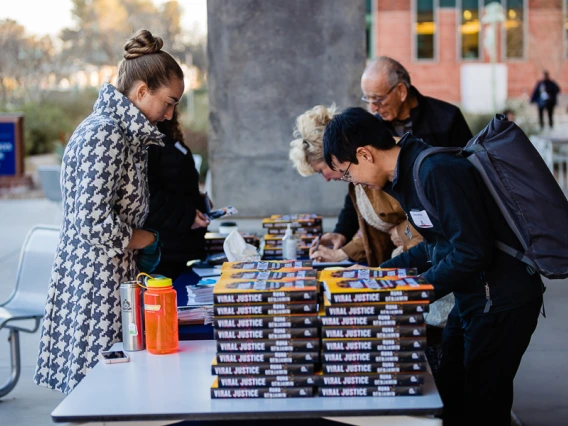 Attendees at book release table for keynote registration