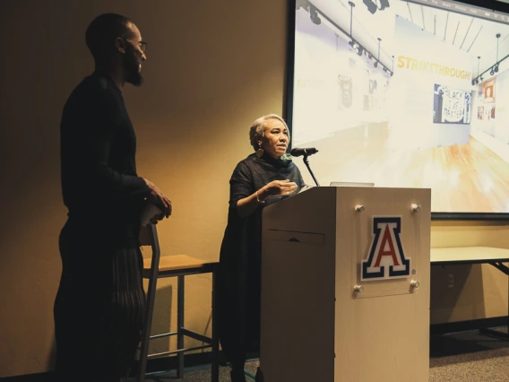 Gloria at podium with Silas