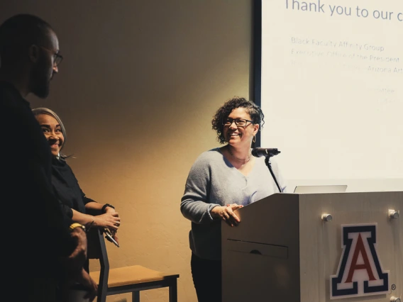 Amy at podium with Gloria and Silas