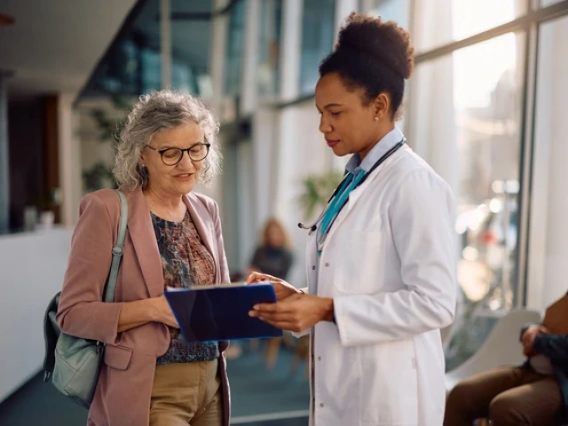 a doctor speaking with a patient while holding a clipboard