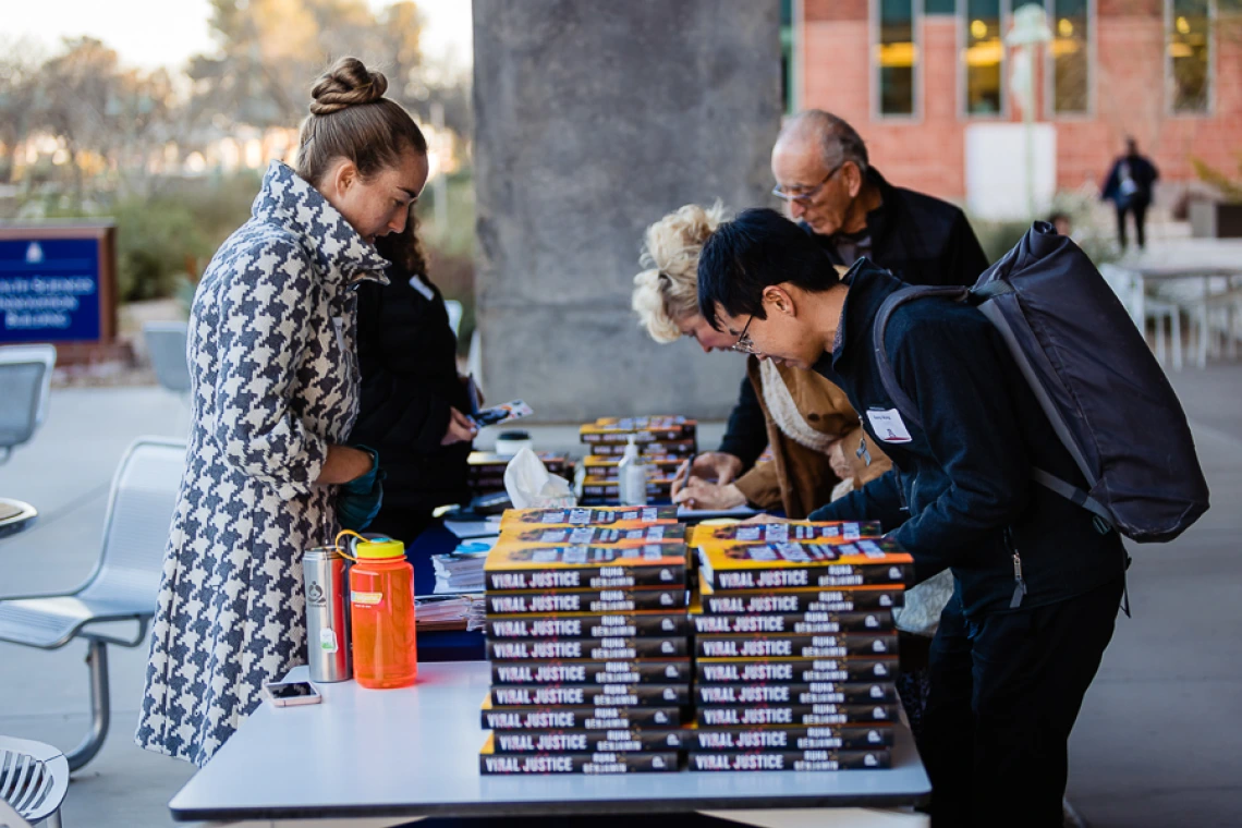 Attendees at book release table for keynote registration