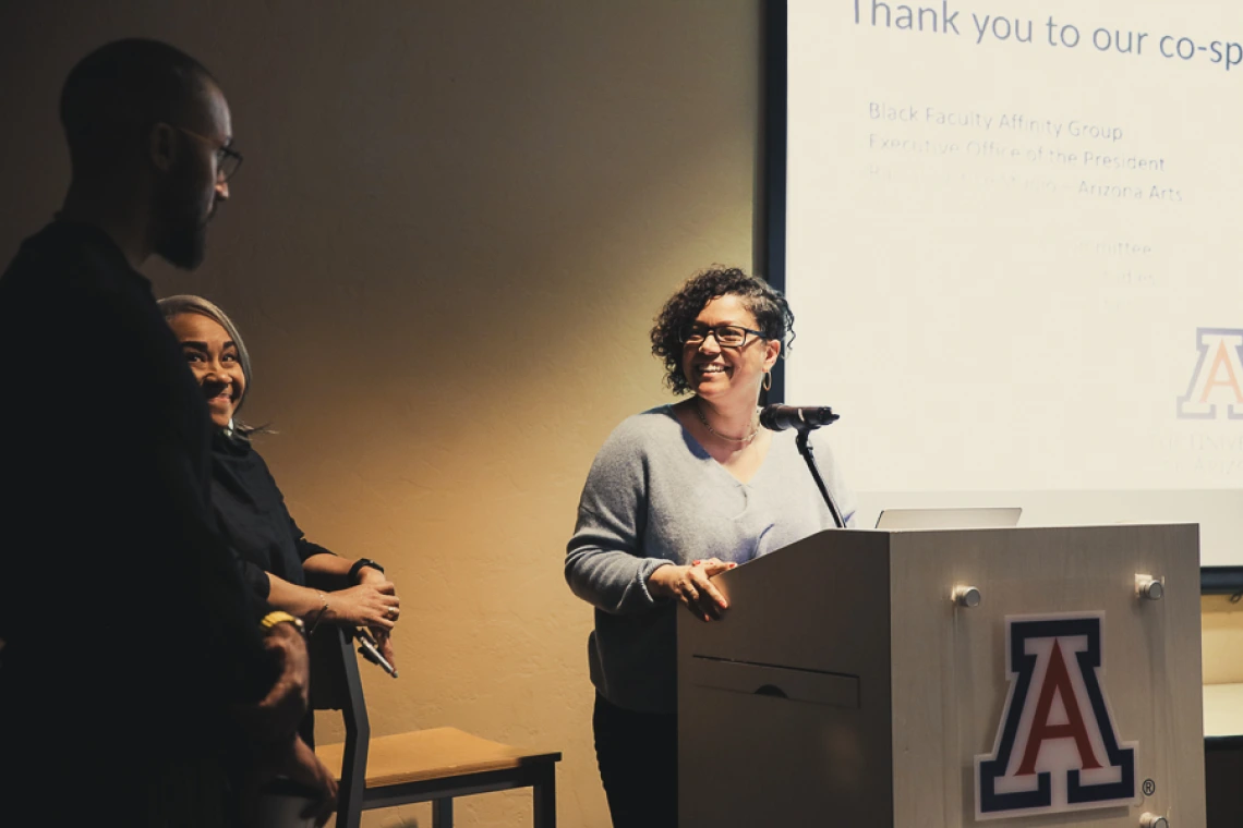 Amy at podium with Gloria and Silas