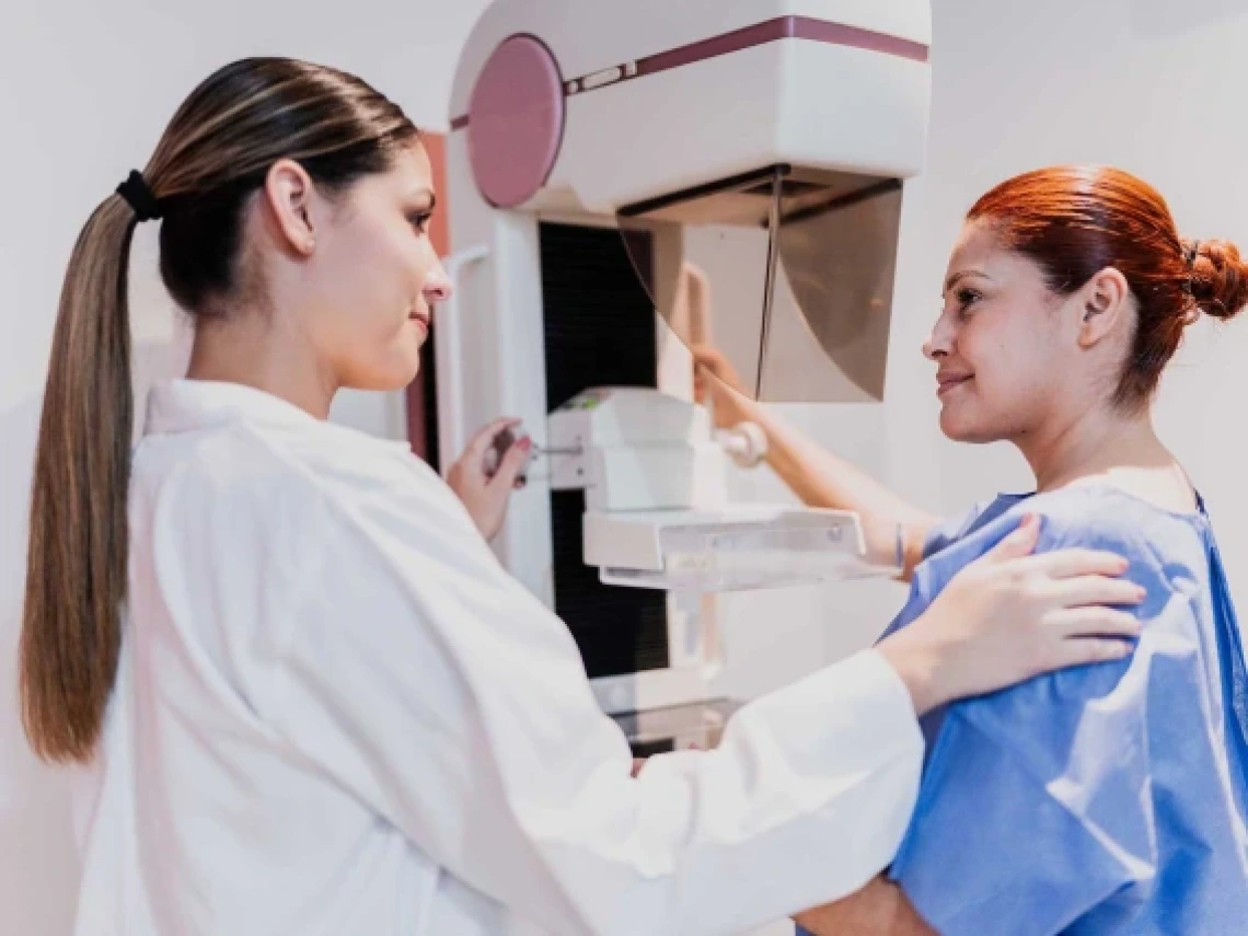 a medical professional helping a patient with a diagnostic machine in an exam room