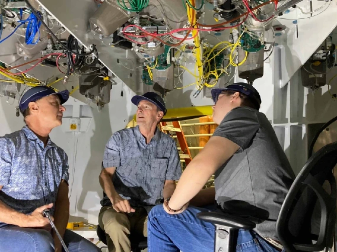 Buddy Martin (center) inspects components inside the support cell with Giant Magellan Telescope engineers Tomas Krasuski (left) and Colby Gottschalk (right).