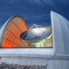 At night, the open dome reveals the dish of the Arizona Radio Observatory's 12-meter Telescope on Kitt Peak 