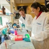 two people smiling and working inside a lab at UACI