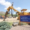 a group gathered near the san xavier mining laboratory with a large mining machine nearby