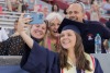 a graduate taking a selfie with parents